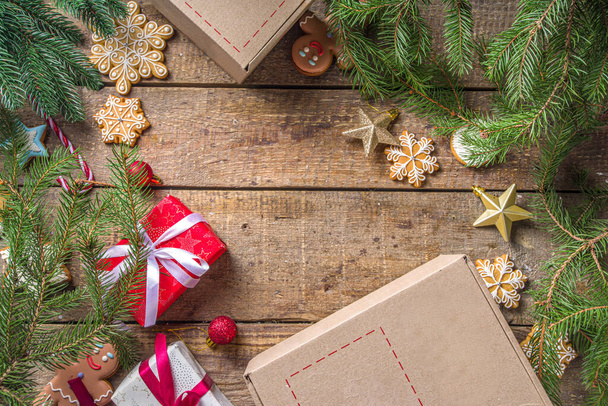 Χριστουγεννιάτικο πακέτο δώρου. Ανταλλαγή δώρων Χριστουγεννιάτικη Πρωτοχρονιά έννοια για covid-19 πανδημία. Μυστικό παιχνίδι μετά τον Άγιο Βασίλη. Συσκευασία δώρα, μπισκότα σε δέμα. Ξύλινο φόντο, με κλαδιά χριστουγεννιάτικου δέντρου και διακόσμηση - Φωτογραφία, εικόνα