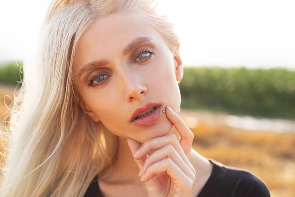 Close-up portret młodej ładnej blondynki na polu pszenicy. - Zdjęcie, obraz