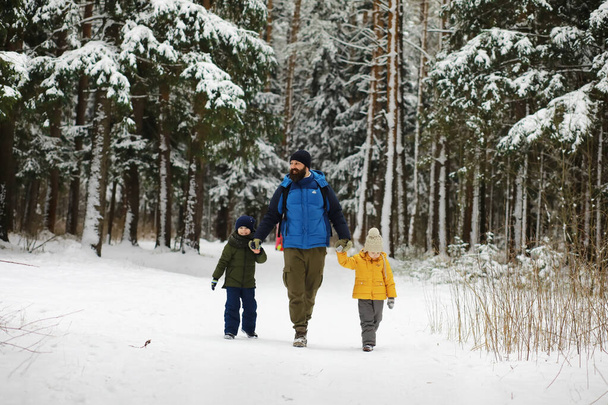 Щаслива сім'я грає і сміється взимку на свіжому повітрі в снігу. Міський парк зимовий день
. - Фото, зображення