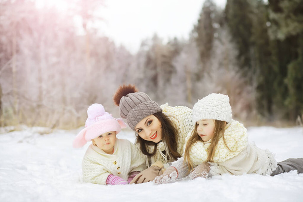 Familia feliz jugando y riendo en invierno al aire libre en la nieve. Parque de la ciudad día de invierno - Foto, imagen