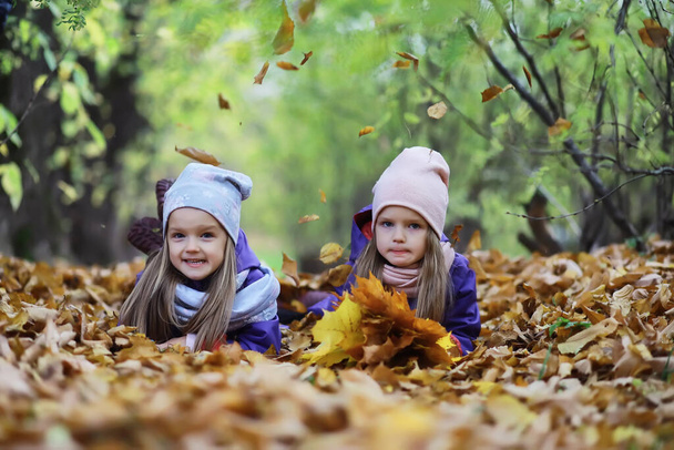 Kinderen voor een wandeling in het herfstpark. Bladeren vallen in het park. Familie. Vallen. Geluk. - Foto, afbeelding