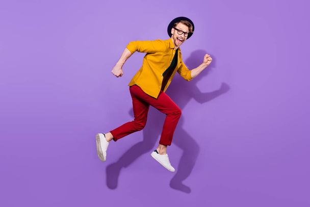 Full side profile side photo of young guy happy positive smile go walk run fast jump isolated over purple color background - Φωτογραφία, εικόνα