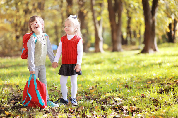 Parkta yürüyüş yapmak için çantalı çocuklar. Okul tatili. Çocuk eğitiminin başlangıcı.. - Fotoğraf, Görsel