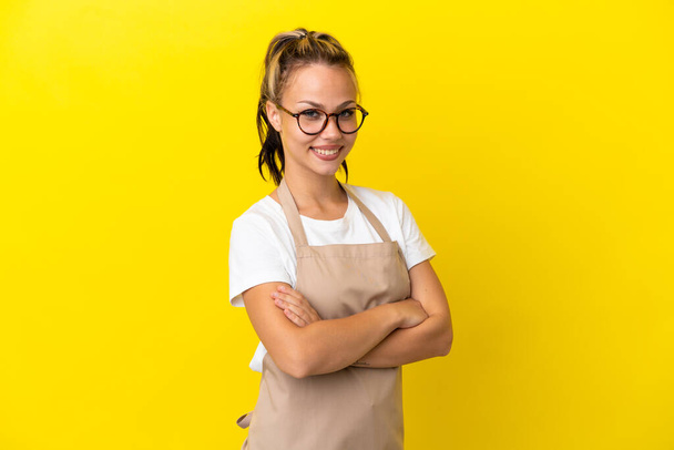 Serveur restaurant fille russe isolé sur fond jaune avec les bras croisés et impatient - Photo, image