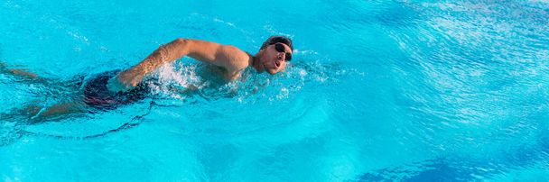 水泳スポーツ選手は、レースのためのプールトレーニングで水泳。屋外フィットネススタジアムで水の中で心臓を動作するプロの男性のウォータースポーツ大人。バナーパノラマ作物 - 写真・画像