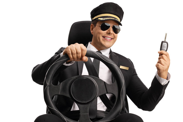 Chauffeur driving a car and showing a key isolated on white backaground - Valokuva, kuva