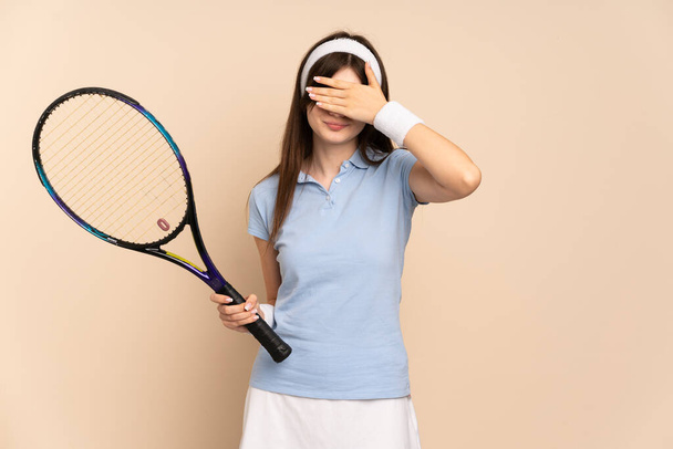 Genç Ukraynalı tenisçi kız izole duvarın üstünde gözleri elleriyle kapatıyor. Bir şey görmek istemiyorum. - Fotoğraf, Görsel