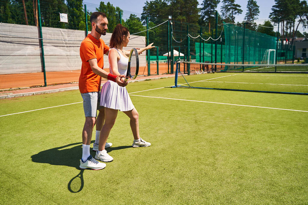Experienced trainer teaching a beginner player to hold the racket - Valokuva, kuva