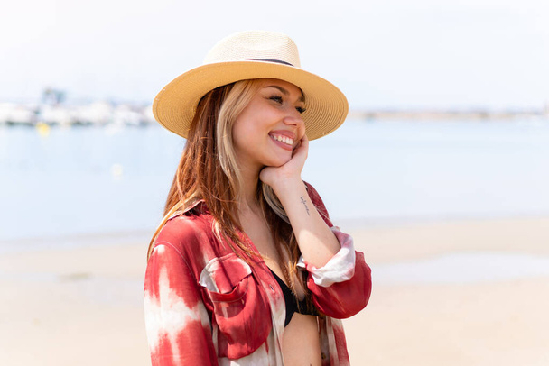 Joven chica rubia bonita en la playa en vacaciones de verano - Foto, imagen