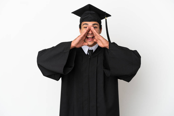 Молодой выпускник университета на изолированном белом фоне кричит и объявляет что-то - Фото, изображение