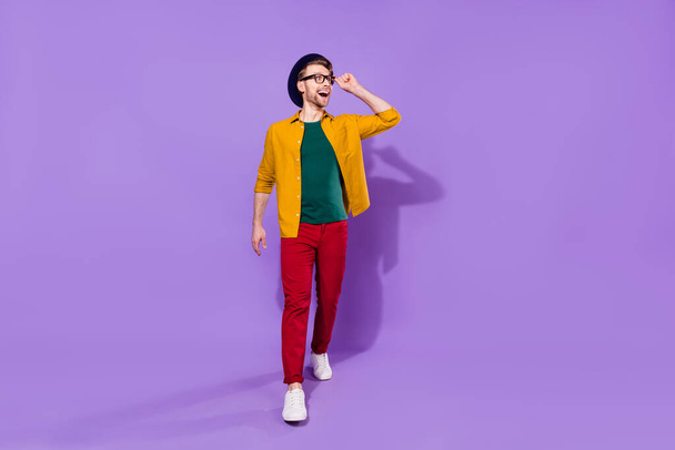 Full length body size view of nice cheerful amazed guy walking looking aside search see isolated over bright violet purple color background - Фото, изображение