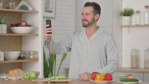 Homem conversando em chamada de vídeo em Smartphone na cozinha - Foto, Imagem