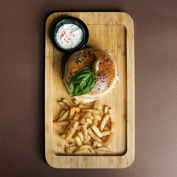Beef Burger with fries and mayo sauce top shot in a wooden tray - Foto, Imagen