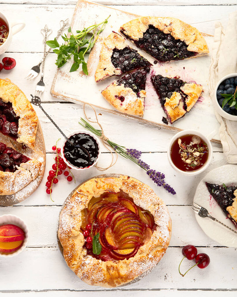 Homemade summer pies or galettes on white wooden table. Top view, flat lay, copy space  - Фото, зображення