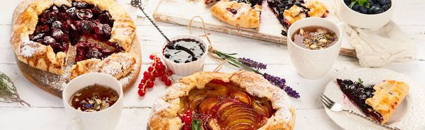 Homemade summer pies or galettes on white wooden table. Panorama, banner - 写真・画像