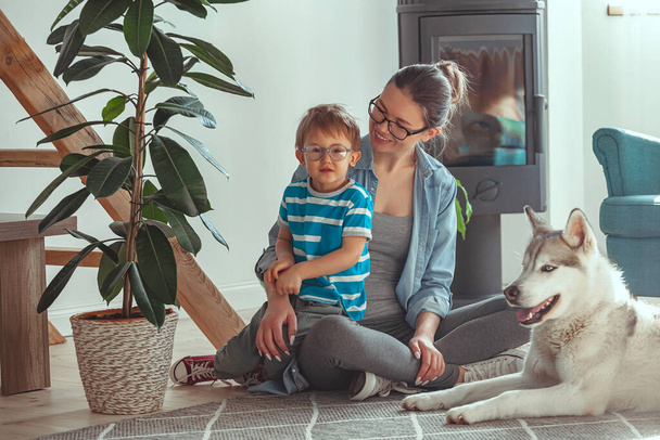 Mom and child have fun and play with the dog at home - Photo, Image