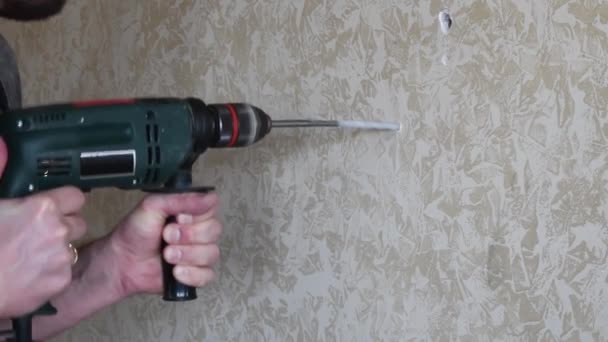 Male hands make hole using electric drill with twist drill bit - Footage, Video