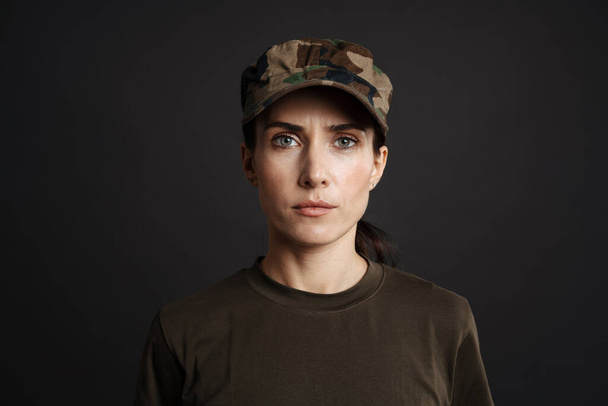 Grave bella donna soldato posa e guardando la fotocamera isolata su sfondo nero - Foto, immagini
