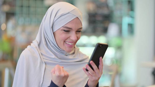 Arab nő ünnepli siker Smartphone  - Fotó, kép