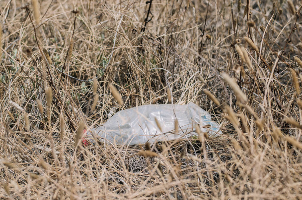 botella de plástico arrugado en el campo, contaminación ambiental - Foto, Imagen