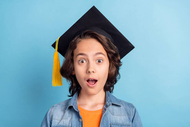 Photo of young preteen boy happy positive smile graduate college black hat isolated over blue color background - Φωτογραφία, εικόνα