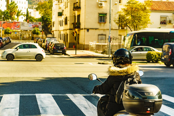 Motorcyclist driving motorbike on city street. Urban view - Zdjęcie, obraz