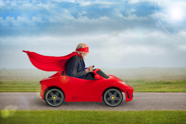 Supereroe anziano alla guida di una macchina sportiva giocattolo
 - Foto, immagini