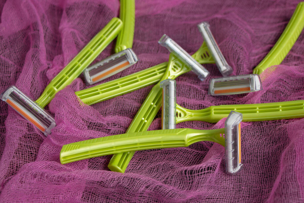 personal green razors on a red background. Lots of sharp new razors - Photo, Image