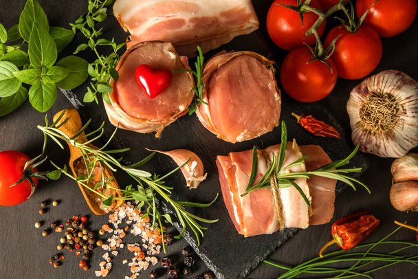 Fresh raw pork tenderloin with bacon on slate board. Meat ready for grilling. Diet food. - Foto, immagini