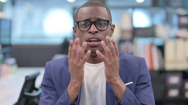 Portret van teleurgestelde jonge Afrikaanse zakenman reagerend verlies - Foto, afbeelding