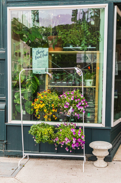 Colfax, Washington, EE.UU. 22 de mayo de 2021. Colgando cestas de flores fuera de una floristería pequeña ciudad. - Foto, Imagen