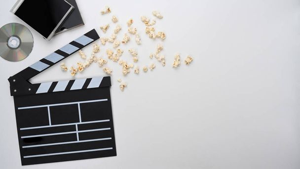 Clapperboard and popcorn on white background. Top view. - Photo, Image