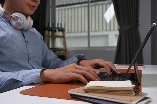 Rajattu laukaus hymyilevä nuori mies freelancer työskentelee verkossa tietokoneen tabletti kotona. - Valokuva, kuva