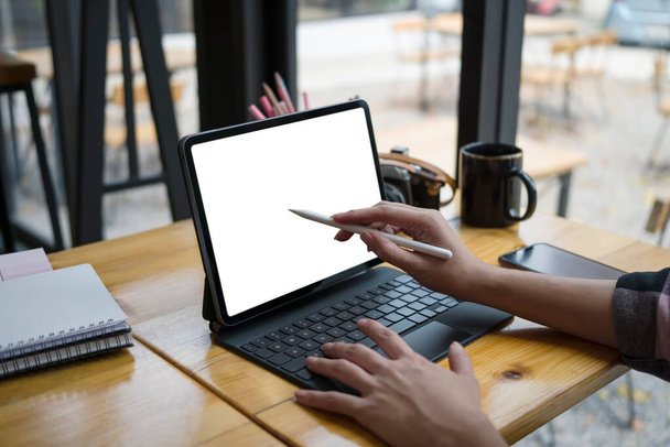 Vista de cerca del diseñador femenino que sostiene la pluma del lápiz de aguja que apunta en la pantalla de la tableta digital. - Foto, Imagen