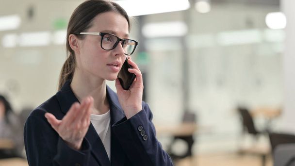 Portrait of Young Businesswoman Talking on Phone - 写真・画像