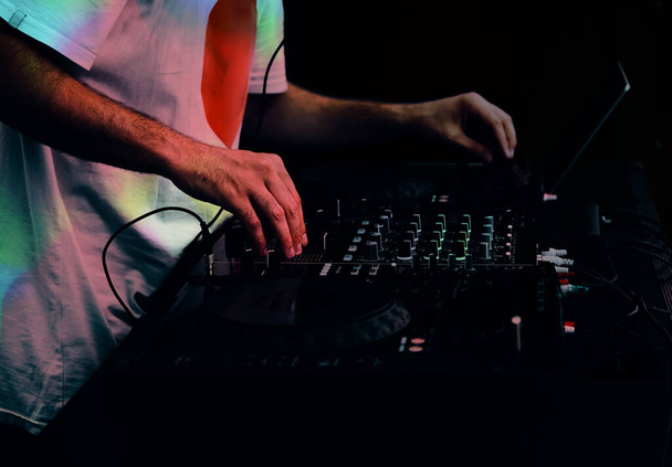 Hip hop DJ scratching music tracks on digital  cd turntables at party in club. Disc jockey plays live set on stage of music hall  - Fotó, kép
