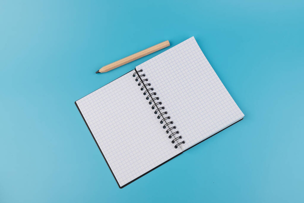 Bleistifte und leeres Notizbuch auf blauem Hintergrund mit Kopierraum - Foto, Bild