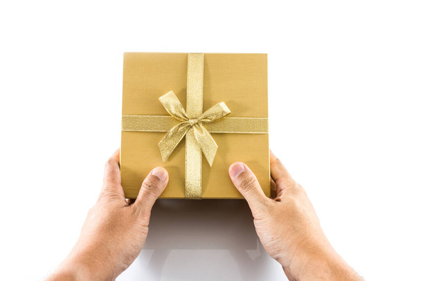 Рука дать золотой подарок коробку с золотым луком изолированы на белом фоне - Фото, изображение