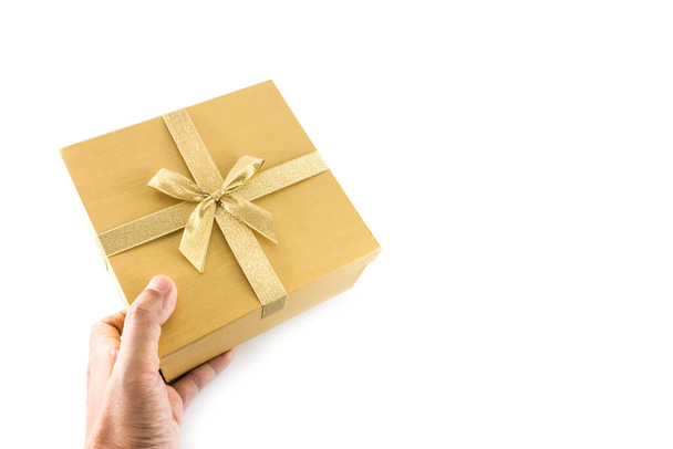 Рука дать золотой подарок коробку с золотым луком изолированы на белом фоне - Фото, изображение