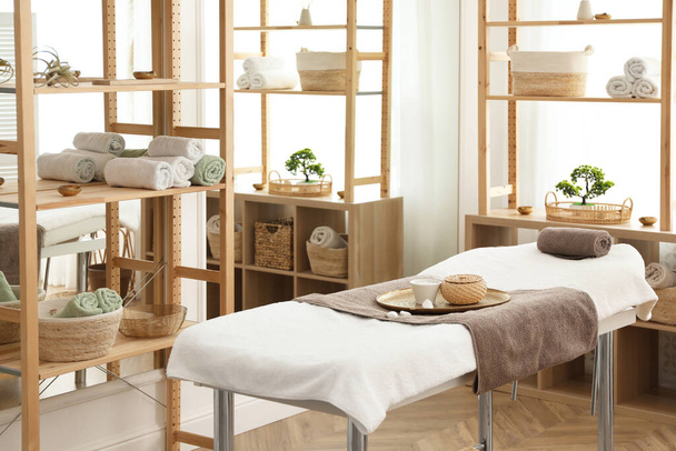 Stylish room interior with massage table in spa salon - Foto, afbeelding