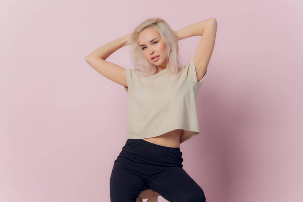 young pretty blonde woman laughing happily with arms crossed, with a relaxed, positive and satisfied pose against pink flat wall. - Фото, зображення