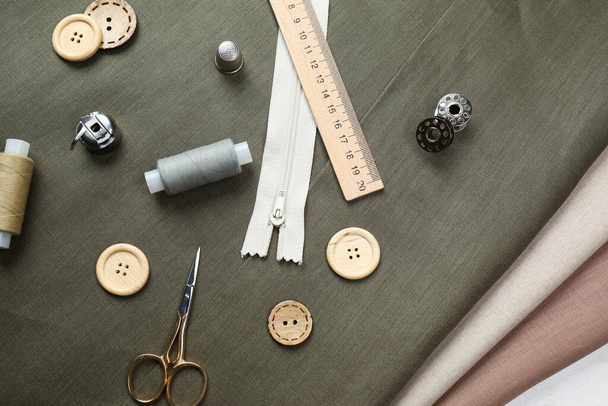 Different sewing supplies and accessories on fabric, flat lay - 写真・画像