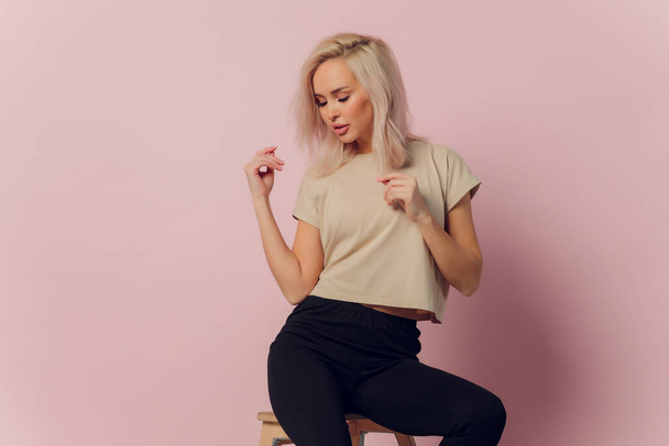 young pretty blonde woman laughing happily with arms crossed, with a relaxed, positive and satisfied pose against pink flat wall. - Φωτογραφία, εικόνα