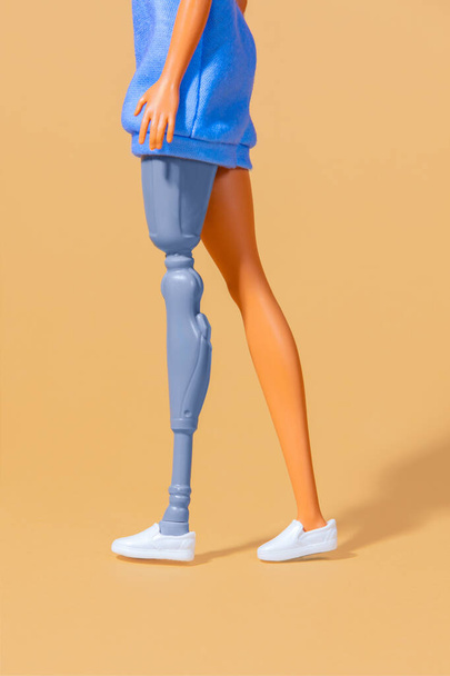 vrouwelijke pop met een kunstbeen. Focus op het lage deel van het lichaam - Foto, afbeelding