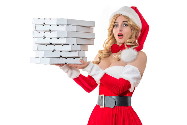 Pizzalähetyskonsepti. Joulupukin rouva hymyilee onnellisena. Kaunis nainen punaisessa mekossa. Pin-up tyttö Joulupukin hatussa. Naisten joulujuhla-asu, ruoan tilaaminen, uudenvuoden ateriapalvelu - Valokuva, kuva