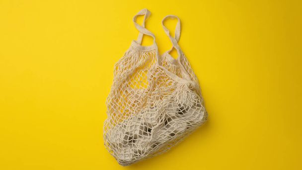 reusable white textile shopping bag with egg cartons on a yellow background, zero waste, banner - Foto, afbeelding