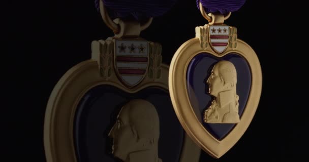 Purppurasydänmitali sotilasansioista pyörii hitaasti mustalla taustalla - Materiaali, video