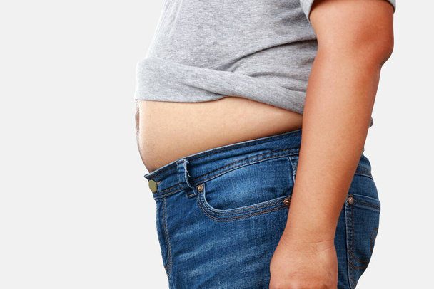 太った男が大量の体重の灰色のシャツを着て大きな腹を示すためにシャツを脱いでください。健康上の問題がある様々な病気のリスクがあります。減量の概念。クリッピングパス - 写真・画像