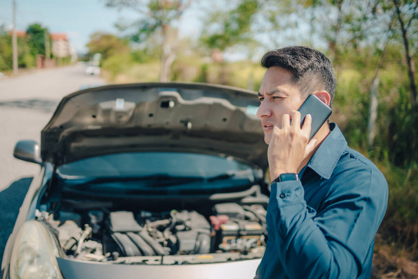 young man calling,  texting for car service on roadside assistance after broken car. Car broken, car breakdown concept. - Foto, Imagem