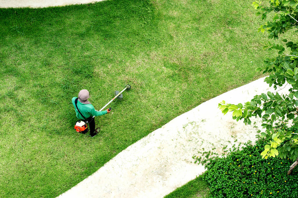 man worker cutting  grass with lawn mower - Foto, afbeelding
